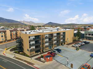 View of apartment building / complex featuring a mountain view and uncovered parking
