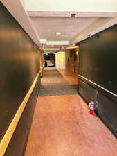 Corridor featuring a textured ceiling