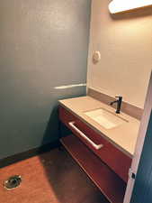 Bathroom with vanity and a textured wall