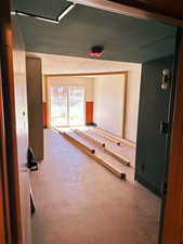 Hall featuring concrete flooring and a textured ceiling