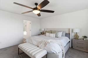 Bedroom featuring carpet, a ceiling fan, and ensuite bath