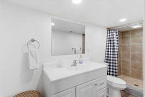 Full bathroom featuring a stall shower, vanity, and recessed lighting