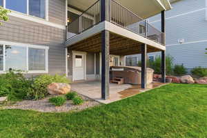 Patio / terrace featuring a hot tub, a patio, and a lawn