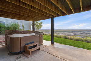 View of patio with a hot tub and a mountain view