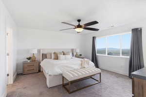 Carpeted bedroom with a mountain view and ceiling fan