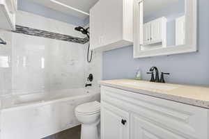Main level suite bathroom, with vanity and a combined bath/sho with marble appearance