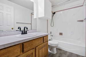 Bathroom featuring a vanity, dark wood-type flooring, and a shower/bathtub combination