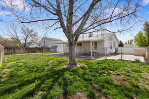 Back of house with a patio, a fenced backyard, a storage shed, and a chimney