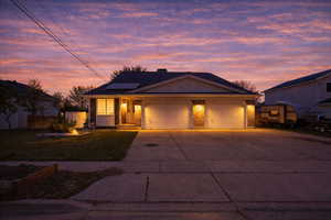 Ranch-style house with solar panels, a 3-car garage, a concrete driveway, and covered porch