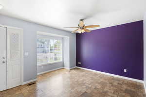 Empty room with stone tile flooring and ceiling fan