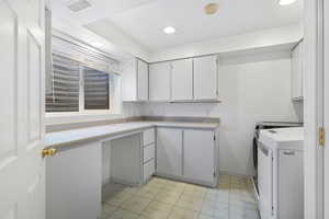 Laundry room with light floors, washing machine and dryer, recessed lighting, and cabinet space