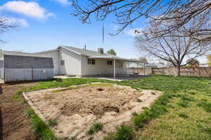 Rear view of house with a patio area, a fenced backyard, and a storage shed
