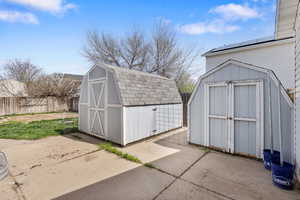 View of shed with a fenced backyard and solar panels