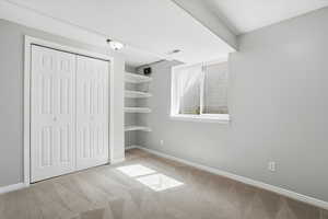 Unfurnished bedroom featuring light colored carpet and a closet