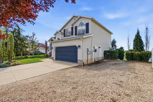 View of home's exterior with driveway, a garage, and a balcony
