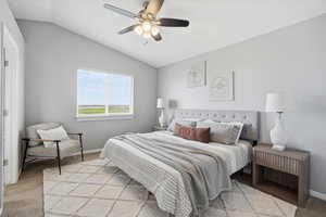 Bedroom with light colored carpet, lofted ceiling, and a ceiling fan