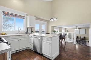 Kitchen featuring a peninsula, light countertops, dark wood-type flooring, white cabinetry, and a ceiling fan