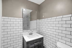 Bathroom featuring vanity and tile walls