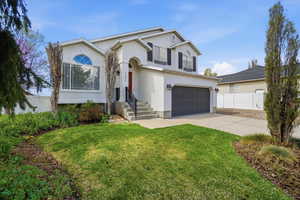 View of front of home featuring stucco siding, an attached garage, and driveway
