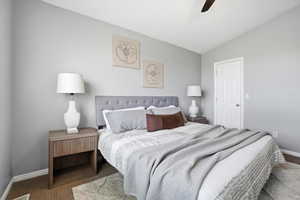 Carpeted bedroom with lofted ceiling and ceiling fan