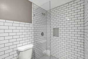 Bathroom with a tile shower and tile walls
