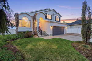 Traditional-style house with stucco siding, an attached garage, and driveway