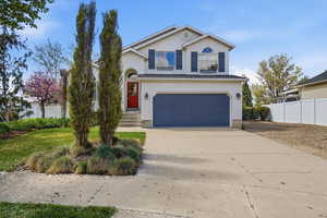 Traditional home featuring concrete driveway, an attached garage, and stucco siding