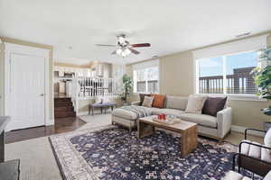 Living area with ceiling fan and dark wood finished floors