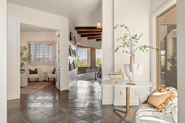 Corridor with stone tile floors and beam ceiling