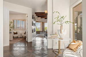 Corridor with stone tile floors and beam ceiling