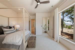 Bedroom featuring connected bathroom, light colored carpet, and a ceiling fan