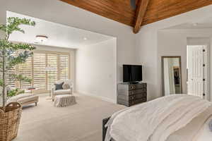 Bedroom with carpet and a wood ceiling with exposed beams