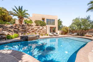 Combined pool / hot tub with a patio and a fenced backyard