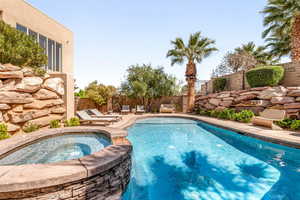 Integrated pool / spa with a fenced backyard and a patio