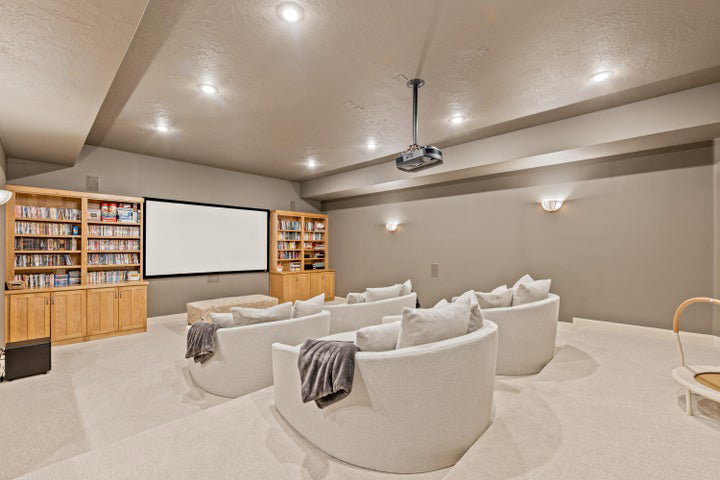 Carpeted home theater room featuring recessed lighting and a textured ceiling