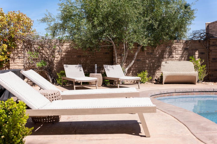 View of swimming pool featuring patio surround and a fenced backyard