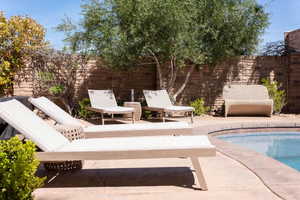 View of swimming pool featuring patio surround and a fenced backyard