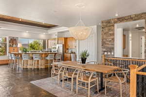 Dining space with stone tile floors and suspended lighting