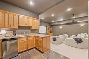 Kitchen with dishwasher, open floor plan, stone tile flooring, a peninsula, and recessed lighting