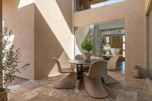 Dining room featuring a textured wall, stone tile floors, and a high ceiling