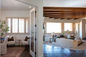 Living area featuring stone tile flooring and beam ceiling