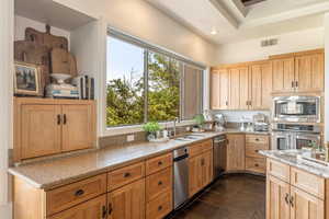 Kitchen with light stone countertops, stainless steel appliances, and light wood finish cabinets