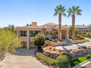 View of front of house with a garage, stucco siding, concrete driveway, stone siding, and a patio
