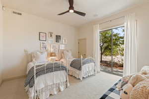 Bedroom with access to exterior, light colored carpet, and a ceiling fan