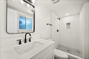 Full bath with a stall shower, vanity, and recessed lighting