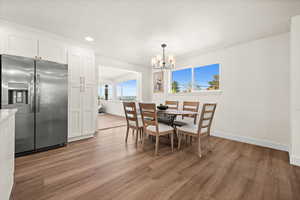 Dining area with light wood-type flooring and hanging lights