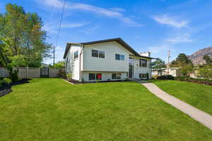 Back of property with brick siding, a chimney, and a gate