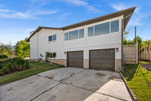 View of front of house featuring concrete driveway, a garage, and brick siding