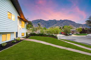 Yard at dusk with a mountain view, a yard, and a residential view
