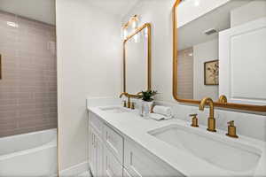 Full bath with double vanity and shower / washtub combination